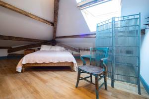 a bedroom with a bed and a chair and a window at Sol By Silastur in Villaviciosa