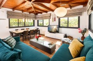 a living room with a blue couch and a table at וילה מקסים בחוסן - וילה מהממת עם בריכה, ג'קוזי וסאונה in H̱osen