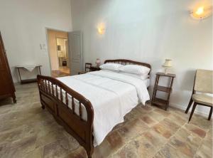 a bedroom with a large bed with white sheets at La maison boîte à gâteaux in Lapalme +1 photo