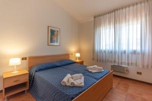 a bedroom with a bed with two towels on it at Residence Albarella in Isola Albarella