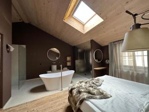 a bedroom with a bath tub and a bed and a sink at La Maison 35 - Bruneck - zentral gelegene Appartments in Brunico