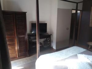 a bedroom with a bed and a tv and a mirror at Only for two Giumbabulla in Ragusa