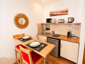 a kitchen with a table with two chairs and a sink at Residence Akantha in Nice