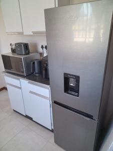 a stainless steel refrigerator in a kitchen with a microwave at M's guest place Nata in Nata