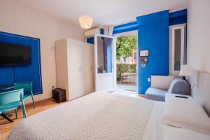 a bedroom with blue walls and a bed and a desk at Soffio Di Mare in Camogli