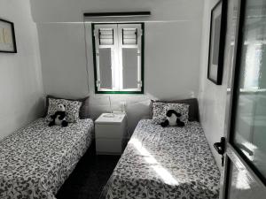 two beds in a small room with a mirror at Maison bord de mer Calypso in Punta Mujeres