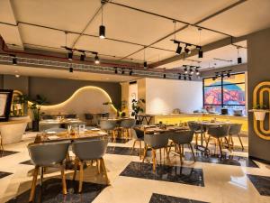 a restaurant with tables and chairs in a room at Soho Suites in Bedla