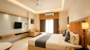 a hotel room with a bed and a flat screen tv at Soho Suites in Bedla