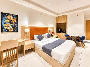 a hotel room with a bed and a desk at Soho Suites in Bedla