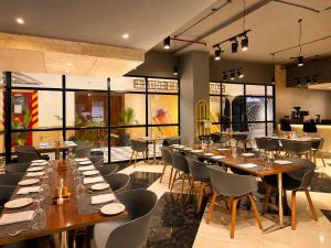 a restaurant with long wooden tables and chairs at Soho Suites in Bedla +4 photos