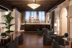 a lobby with a bar with chairs and tables at Palazzo De Polo in Venice