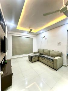 a living room with a couch and a television at Cozy 2BHK with Balcony & Kitchen in Nagpur
