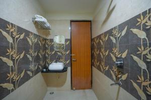 a bathroom with a toilet and a sink in it at Hotel Kiaara in Varanasi