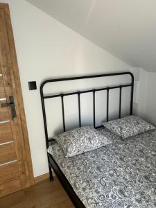 a bed with two pillows on it in a room at TINY HOUSE domek do wynajęcia in Olsztyn