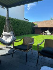 two chairs and a hammock on a patio at TINY HOUSE domek do wynajęcia in Olsztyn