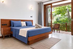 a bedroom with a bed and a balcony at Darlina Hiriketiya in Hiriketiya