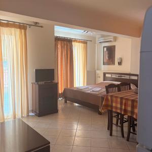a bedroom with a bed and a table and chairs at Dais Apartments in Mitika