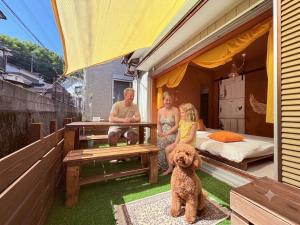 a family sitting on a patio with a dog at villa Morocco in Nagasaki