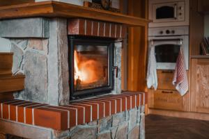 a brick fireplace with a fire in it at U Hani in Bańska Wyżna