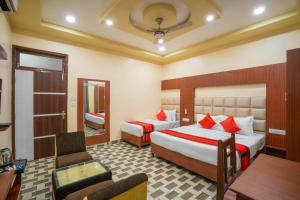 a hotel room with two beds and a table at Hotel Kiaara in Varanasi