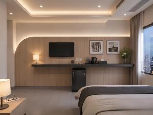 a hotel room with a bed and a flat screen tv at เดย์ อินน์ บาย วินด์แฮม ระยอง อู่ตะเภา in Ban Chang