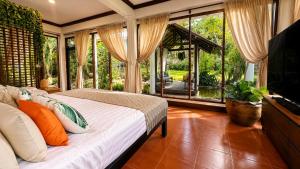 a bedroom with a bed and a television in a room at Nong Thale Garden in Ban Khao Klom
