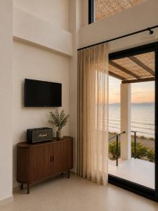 a living room with a television and a large window at athanasia sea view home front house in Polychrono