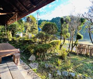 a view of a garden with a wooden picnic table at ゲストハウス やまんなか in Kamida
