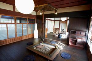 a living room with a fireplace and a table at ゲストハウス やまんなか in Kamida