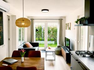 a kitchen and living room with a couch and a table at Steam & Dream - Hottub & Sauna Retreat - Free WiFi - Full Privacy - Luxury Experience in Heinkensand