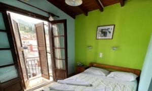 a green bedroom with a bed and a window at samos town hostel in Samos