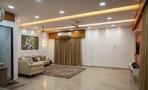 a living room with a couch and a tv at Gaikar Farm & Resort in Murbād