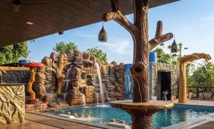a water park with a waterfall in the background at Gaikar Farm & Resort in Murbād
