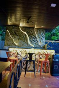 a restaurant with chairs and a stone wall at Gaikar Farm & Resort in Murbād