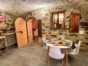 a dining room with a table and white chairs at B&B FANCHETTI 1938 in San Sebastiano