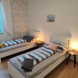 two beds in a room with two lamps on tables at Ferienwohnung Einsiedler - für 4 Personen mit Terrasse und Grill in Windisch Minihof +23 photos