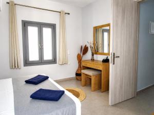 a bedroom with a bed and a mirror and a desk at Blue Sea Paros Aegean Horizon in Drios