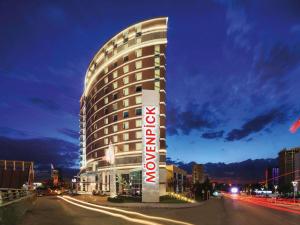 ein Hotelgebäude mit einem Schild davor in der Unterkunft Movenpick Hotel Ankara in Ankara