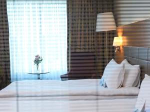 ein Schlafzimmer mit einem Bett und einem Tisch mit einer Blumenvase in der Unterkunft Movenpick Hotel Ankara in Ankara + 83 Fotos