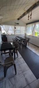a dining room with tables and chairs and windows at Casa Izabela in Năvodari