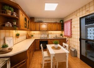 a kitchen with wooden cabinets and a table and chairs at Terrasol Zayamar in Caleta De Velez