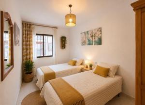 two beds in a small room with at Terrasol Zayamar in Caleta De Velez