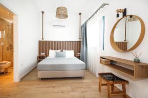 a bedroom with a bed and a mirror at Galaxias Studios in Skala