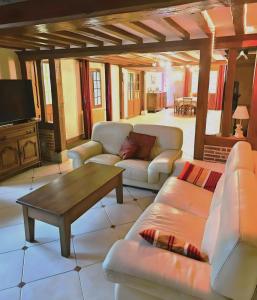 a living room with couches and a coffee table at Le Clos des Argillières in Le Perrey