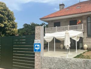 a house with a patio with a white umbrella at Albergue Hostel Barosa in Barro