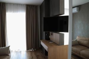 a living room with a flat screen tv and a couch at Galerija Odzaci in Odžaci