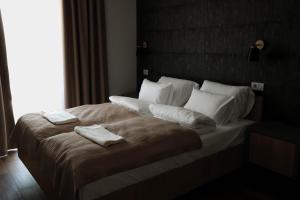 a bedroom with a large bed with two towels on it at Galerija Odzaci in Odžaci