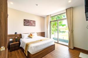 ein Schlafzimmer mit einem Bett und einem großen Fenster in der Unterkunft May The Hotel in Cần Thơ