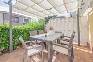 a patio with a table and chairs under a pergola at Heimathafen An Seen & Meer in Korswandt
