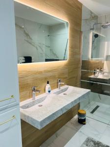 a bathroom with two sinks and a large mirror at L'évasion in Corent +19 photos